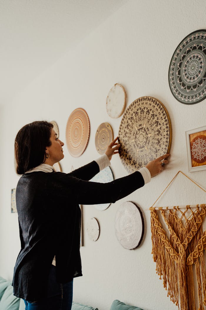 services-06 Adult woman decorates a well-designed interior wall with mandala art pieces.
